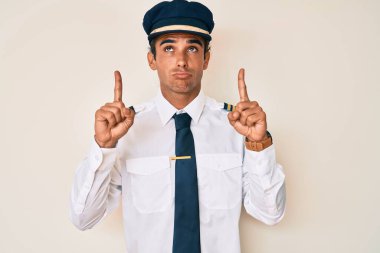 İspanyol pilot üniforması giyen genç adam üzgün ve üzgün görünüyor, parmaklarıyla yön gösteriyor, mutsuz ve depresif.. 