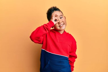 Sıradan bir eşofman üstü giyen küçük İspanyol çocuk gülümsüyor. Mutluluktan gülümsüyor. 