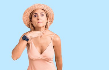 Sarışın, yaz şapkası takan, boğazını bıçak niyetine kesen, saldırganlığı şiddetle tehdit eden genç bir kadın. 