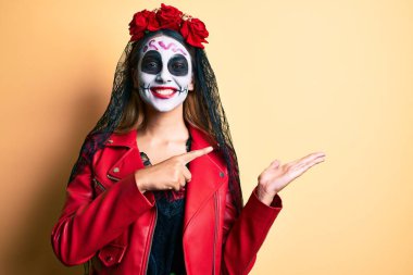 Ölü kostümünü giydiği gün kameraya hayret içinde gülümseyen ve eli ve parmağıyla işaret eden bir kadın.. 