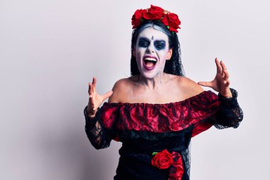 Meksika makyajlı genç bir kadın öfkeyle bağırıyor, elleri boğmaya çalışıyor, deli gibi bağırıyor. 