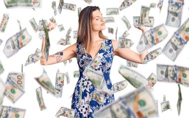 Yazlık elbise giyen güzel beyaz kadın gururla gülümseyen kol kaslarını gösteriyor. fitness konsepti.