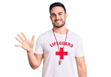 Cankurtaran üniforması giyen genç yakışıklı adam beş numarayı gösterip işaret ederken kendinden emin ve mutlu bir şekilde gülümsüyor.. 