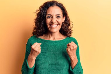 Orta yaşlı, güzel bir kadın gündelik bir süveter giyer. Başarılı olduğu için şaşırır ve şaşırır. Kolları havada ve gözleri kapalı. 