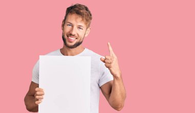 Kafkasyalı genç adam boş afiş tutarken bir fikre ya da soru işaretine şaşırdı. 