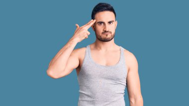 Mayo giyen, kolsuz tişört giyen genç yakışıklı bir adam kendini ve parmaklarını silah gibi gösteren birini vuruyor, intihar ediyor.. 