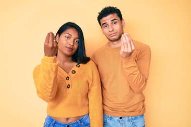 Güzel, Latin, genç bir çift, gündelik giysiler giyip İtalyan jestleri yapıyorlar. Elleri ve parmakları özgüvenli bir ifade. 