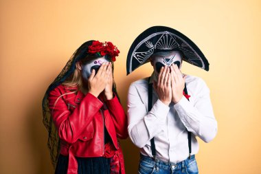 Ölü kostümün giyildiği gün sarı giyinen ve ağlarken yüzünü ellerle kapatan bir çift. depresyon kavramı. 