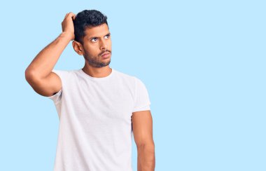 Gündelik kıyafetler giyen genç latin adam soru sorup kafasını karıştırıyor. Şüpheyle kararsız, kafa kafaya düşünerek. Düşünceli kavram. 