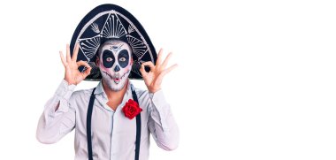 Arka planda ölü kostümü giyen adam şaşırmış ve şok olmuş görünüyor. Tamam sembolünü parmaklarıyla yapıyor. çılgın ifade 