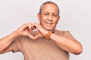 Gri saçlı, sıradan tişörtlü, aşık gülümseyen, elleriyle kalp sembolü yapan son sınıf öğrencisi. romantik kavram. 