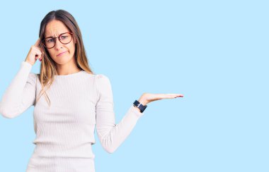 Güzel esmer, beyaz süveter giyen, gözlüklü, açık avuç içiyle fotokopi çeken ve alnını işaret eden güzel bir kadın. Bunu bir düşün.. 