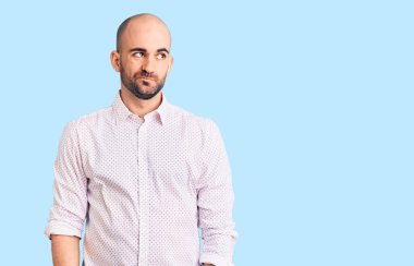 Zarif bir gömlek giyen yakışıklı bir adam gülümseyip yan tarafa bakıyor ve düşünüyor.. 