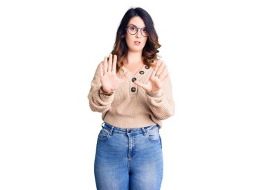 Güzel, genç, esmer bir kadın, günlük kıyafetler ve gözlük takıyor, avuç içlerini hareket ettiriyor, reddediyor ve iğrenç bir ifadeyle reddediyor. Dur ve yasakla. 