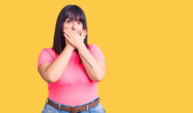 Gündelik kıyafet giyen genç bir kadın yanlışlıkla elleri ile ağzını kapatırken şok oldu. gizli kavram. 