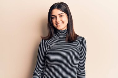 Yüzünde mutlu ve havalı bir gülümseme olan sıradan çizgili tişört giyen genç ve güzel bir kız. şanslı kişi. 