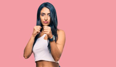 Güzel İspanyol kadın gündelik kıyafetler giyiyor. Yumruk savunma hareketleriyle dövüşmeye hazır. Kızgın ve üzgün yüz, sorundan korkuyor. 