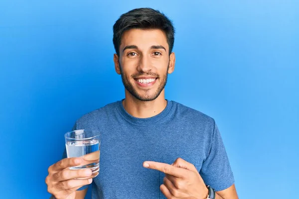 Joven Hombre Guapo Bebiendo Vaso Agua Sonriendo Feliz Señalando Con — Foto de Stock