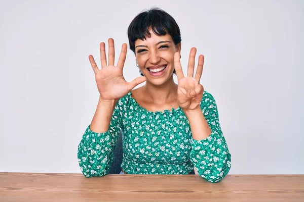 Mooie Brunettte Vrouw Dragen Casual Kleding Zitten Tafel Tonen Wijzen — Stockfoto