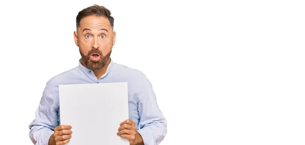 Handsome Middle Age Man Holding Blank Empty Banner Scared Amazed — Stock Photo, Image