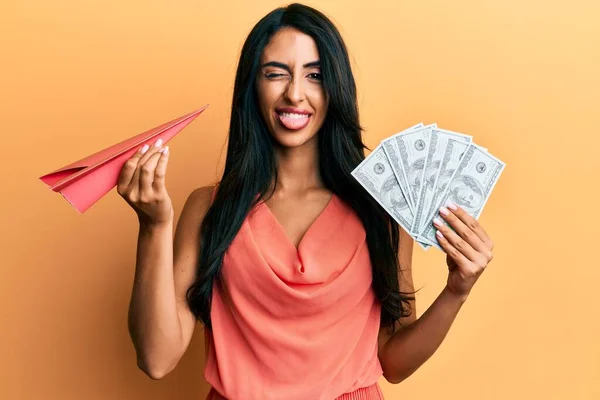 Beautiful Hispanic Woman Holding Paper Plane Dollars Sticking Tongue Out — Stock Photo, Image
