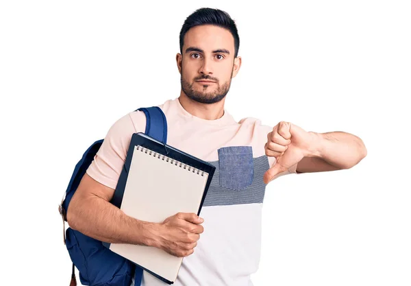 Junger Gutaussehender Mann Mit Studentenrucksack Und Notizbuch Mit Wütendem Gesicht — Stockfoto