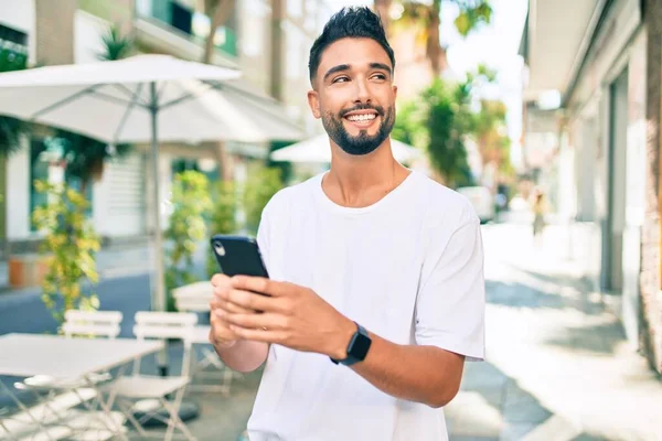 Hombre Árabe Joven Sonriendo Feliz Usando Teléfono Inteligente Ciudad —  Fotos de Stock