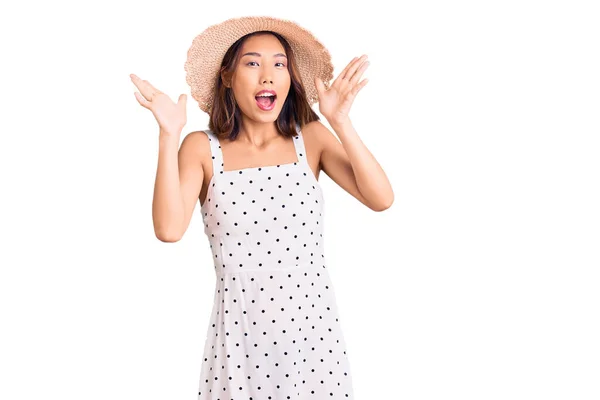 年轻美丽的中国姑娘戴着夏帽 高举双臂 睁开眼睛 兴奋地尖叫着 庆祝着成功 获奖者概念 — 图库照片