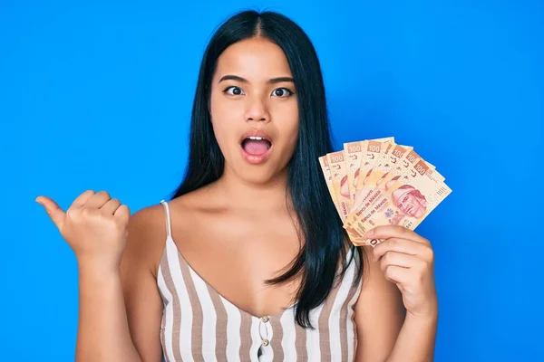 Mladý Krásný Asijské Dívka Držení Mexické Pesos Ukazující Palec Nahoru — Stock fotografie