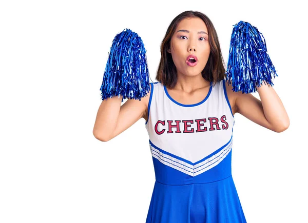 Young Beautiful Chinese Girl Wearing Cheerleader Uniform Holding Pompom Scared — Stock Photo, Image