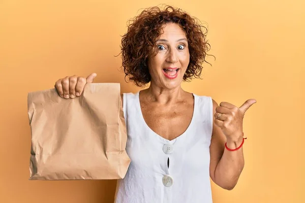 Vacker Medelålders Mogen Kvinna Håller Bort Papperspåse Pekar Tummen Upp — Stockfoto