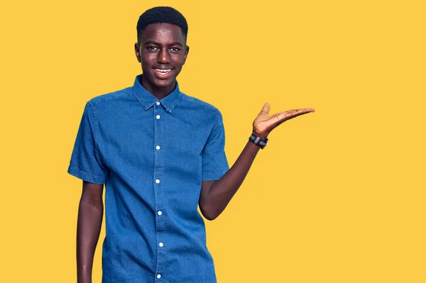 Młody Afrykański Amerykanin Ubrany Luźne Ubrania Uśmiechnięty Pogodny Wskazujący Dłonią — Zdjęcie stockowe