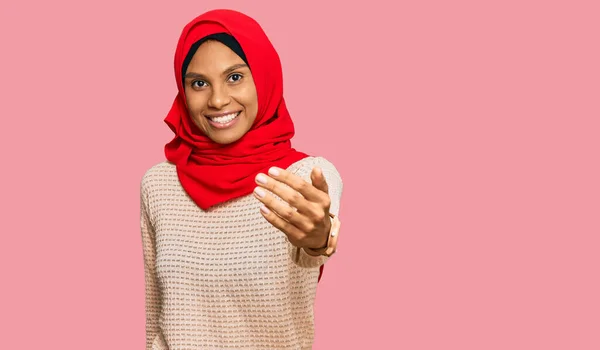 身穿传统伊斯兰头巾的年轻的非洲裔美国妇女开心地微笑着 伸出手掌给予帮助和接受 — 图库照片