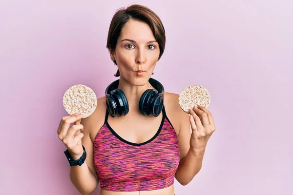 Kısa Saçlı Esmer Kadın Spor Kıyafetleri Giyiyor Pirinç Keki Tutuyor — Stok fotoğraf
