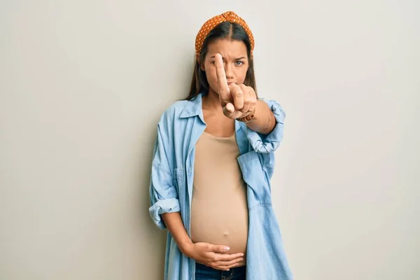 妊娠中のお腹を指で指差して怒りの表情を見せジェスチャーも見せず — ストック写真