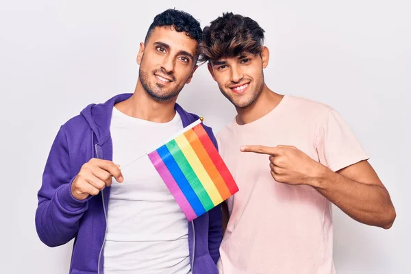 Unga Homosexuella Par Som Håller Regnbågen Lgbtq Flagga Ler Glad — Stockfoto