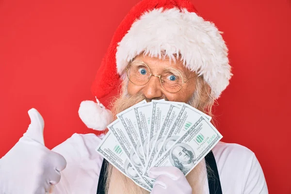 Staruszek Siwymi Włosami Długą Brodą Kostiumie Świętego Mikołaja Trzymający Dolary — Zdjęcie stockowe