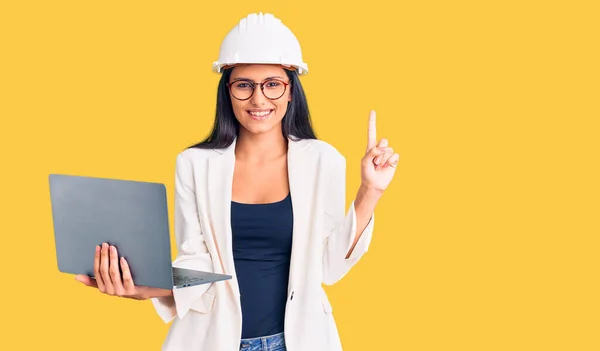 Jovem Bela Menina Latina Vestindo Arquiteto Hardhat Segurando Laptop Surpreso — Fotografia de Stock