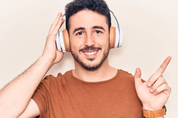 Joven Hispano Escuchando Música Usando Auriculares Sonriendo Feliz Señalando Con — Foto de Stock