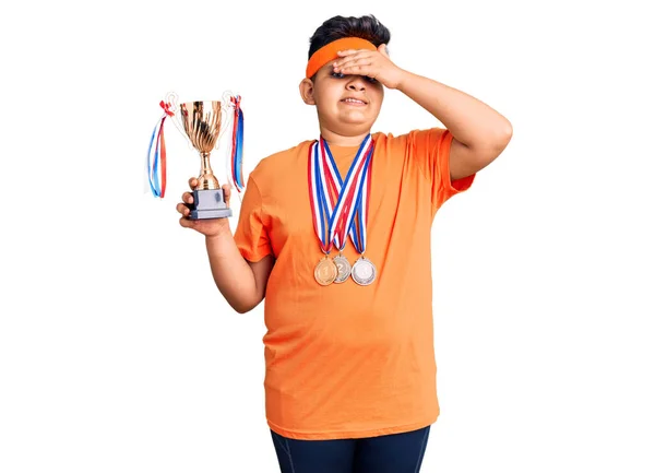 Küçük Çocuk Elinde Şampiyonluk Kupası Tutuyor Madalyalar Takıyor Elleri Kafasında — Stok fotoğraf