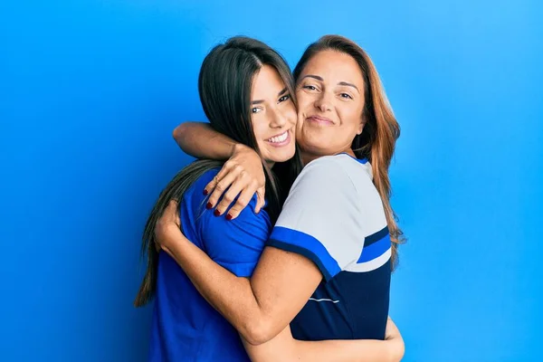 Bela Mãe Hispânica Filha Sorrindo Abraço Feliz Sobre Fundo Azul — Fotografia de Stock