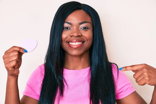 Mujer Afroamericana Joven Sosteniendo Esponja Maquillaje Apuntando Con Dedo Uno —  Fotos de Stock