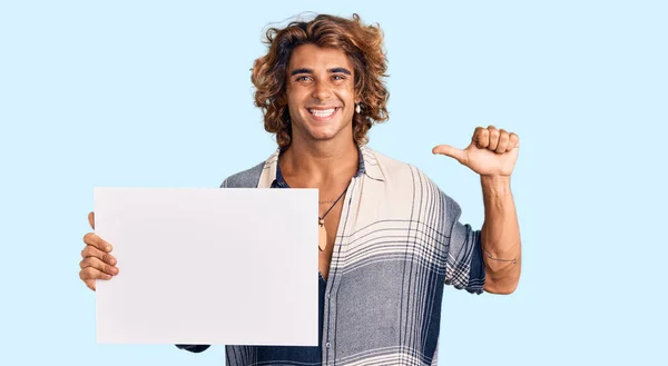 Jovem Hispânico Segurando Banner Vazio Apontando Dedo Para Auto Sorrindo — Fotografia de Stock