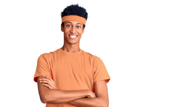 スポーツウェアを着た若いアフリカ系アメリカ人の男性がカメラを見て両腕を組んで笑っている 正の人 — ストック写真