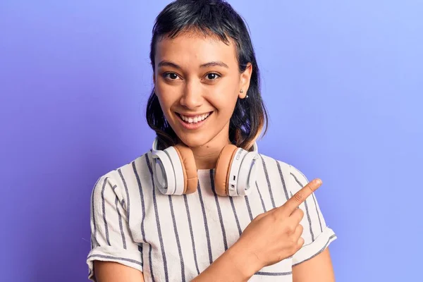 Young Woman Listening Music Using Headphones Smiling Cheerful Pointing Hand — Stock Photo, Image