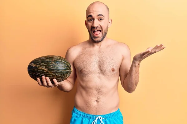 Jovem Careca Bonito Vestindo Roupa Banho Segurando Melão Celebrando Realização — Fotografia de Stock