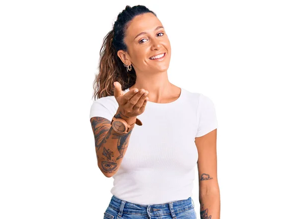 Fiatal Spanyol Tetoválás Visel Alkalmi Fehér Póló Mosolygós Barátságos Kínál — Stock Fotó