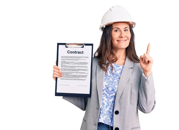 Junge Schöne Brünette Frau Trägt Architekt Hardhat Hält Vertrag Überrascht — Stockfoto