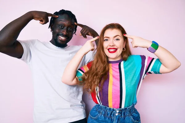 Interracial Couple Wearing Casual Clothes Smiling Pointing Head Both Hands — Stock Photo, Image