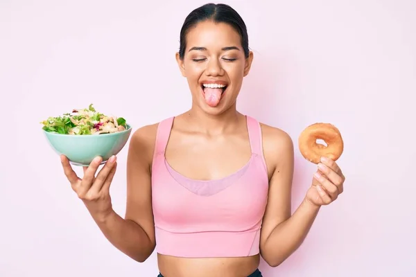 Joven Hermosa Chica Latina Con Ropa Deportiva Sosteniendo Donut Ensalada —  Fotos de Stock